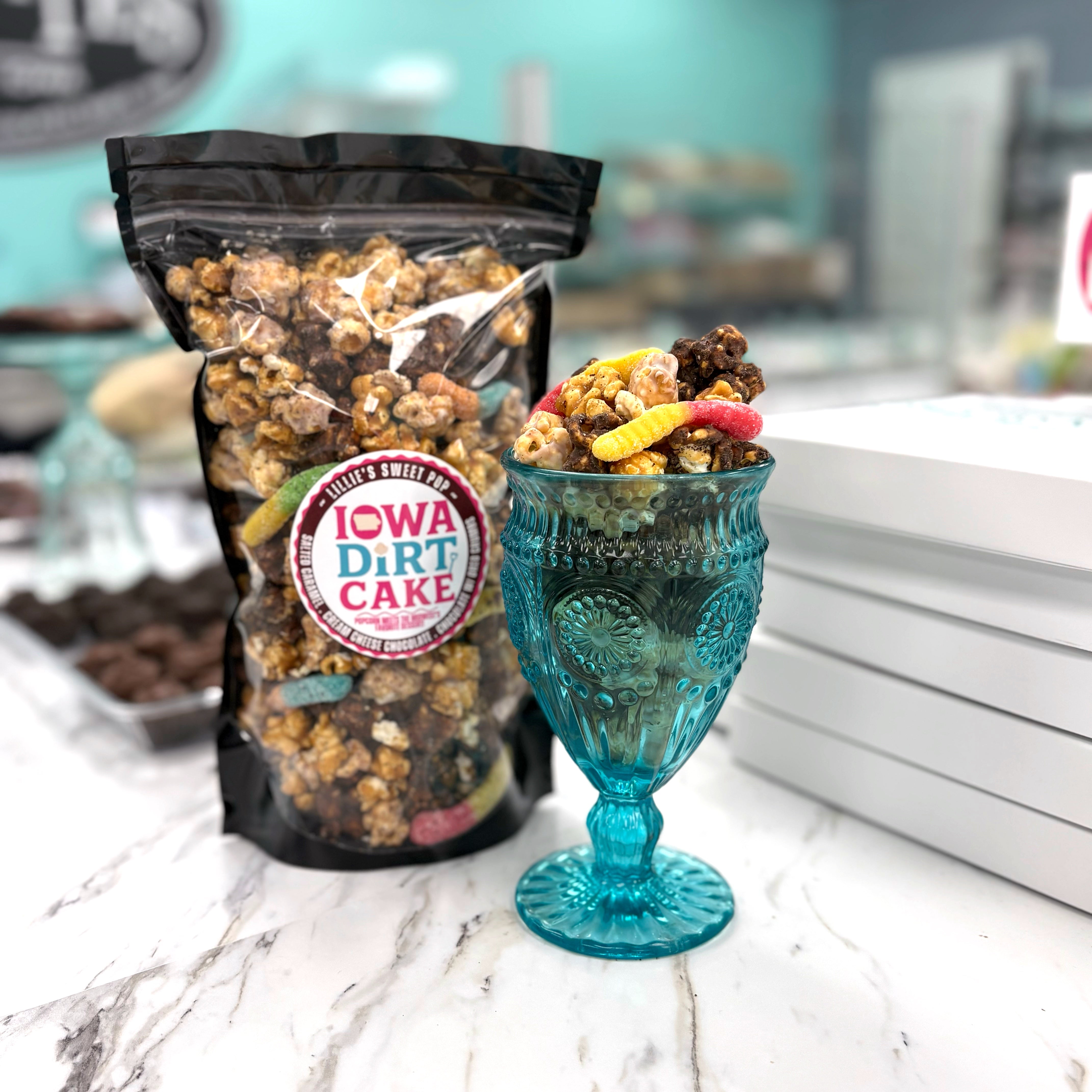 Our Iowa Dirt Cake Popcorn has our cream cheese chocolate popcorn, chocolate covered vanilla salted caramel popcorn, and our buttery vanilla salted caramel popcorn. All dusted in Oreo dust and sprinkled with a few gummy worms.