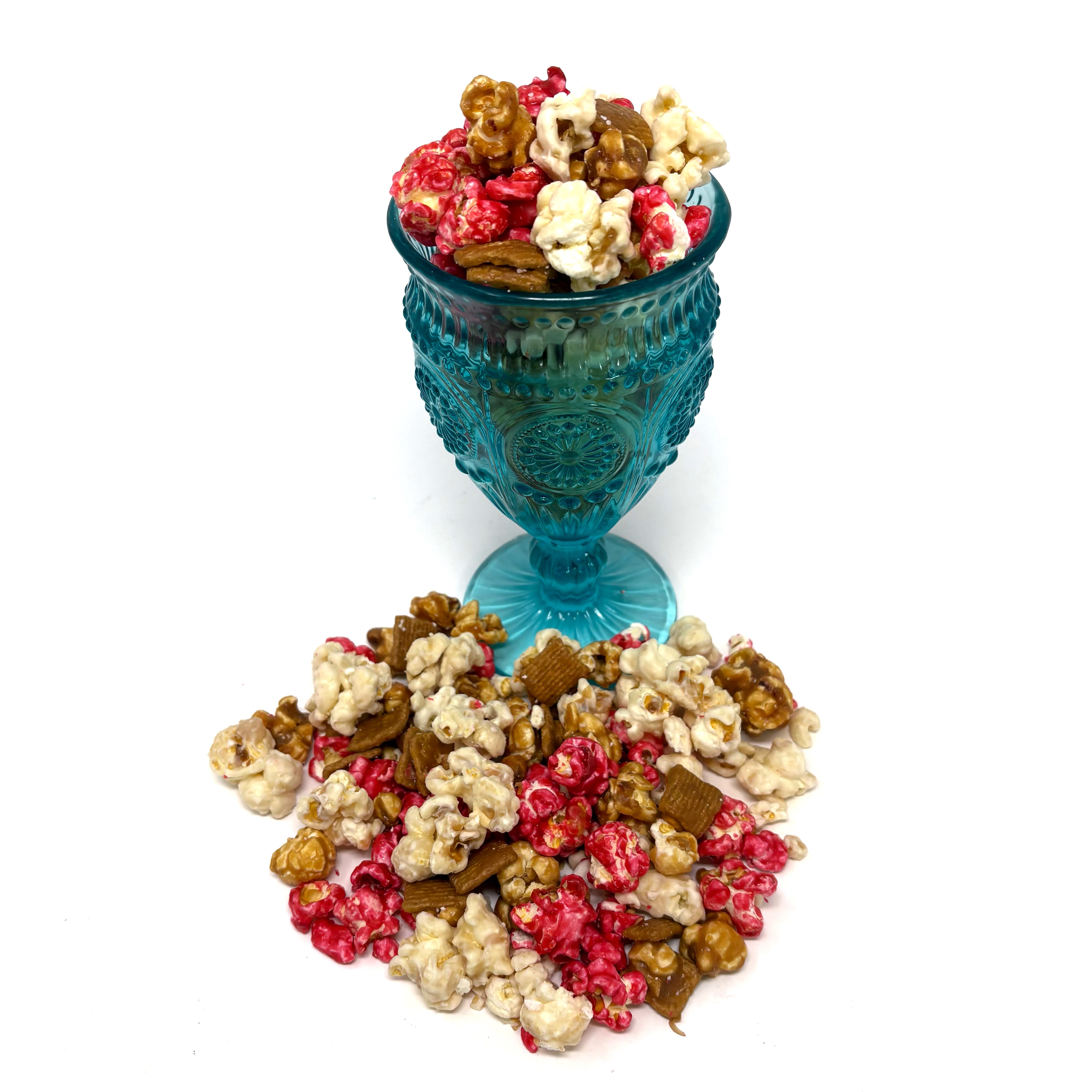 Our Strawberry Cheesecake popcorn has fruity strawberry popcorn, rich cheesecake white chocolate popcorn, and buttery caramel popcorn. Topped off with graham crackers for the perfect touch!